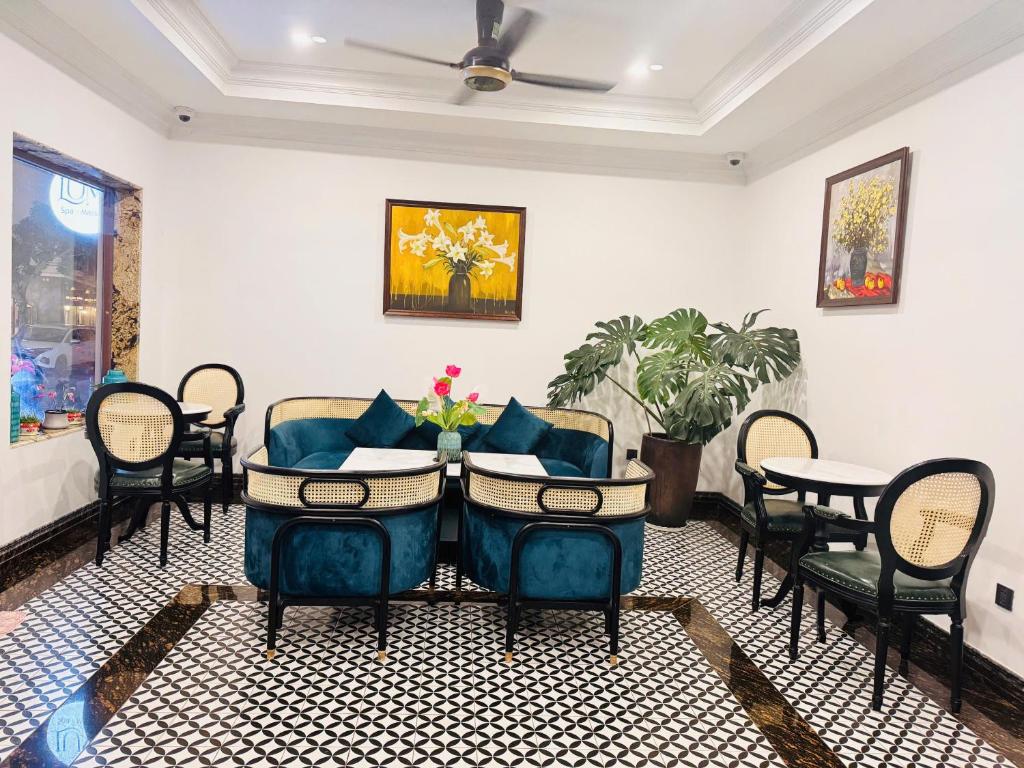 een woonkamer met blauwe stoelen en een tafel bij The Room Hotel - Starbucks in Phu Quoc
