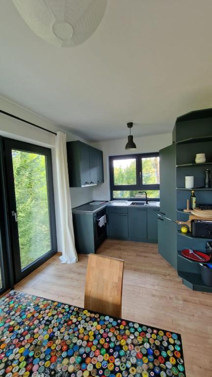 a kitchen with blue cabinets and a wooden floor at Seeblick, ganze Wohnung in Königs Wusterhausen