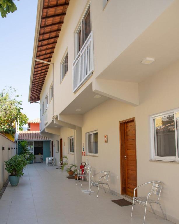 a courtyard of a house with chairs and tables at Flats Premium Jabaquara in Paraty