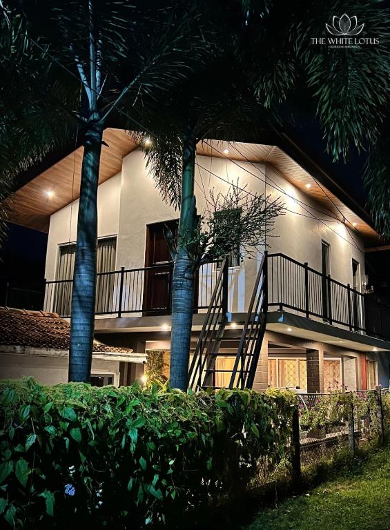 un bâtiment avec des palmiers devant dans l'établissement White Lotus Apartments, à Dankotuwa