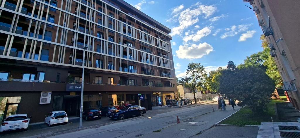 Un edificio en una calle con coches aparcados delante. en Extra Apartman Palata, en Banja Luka