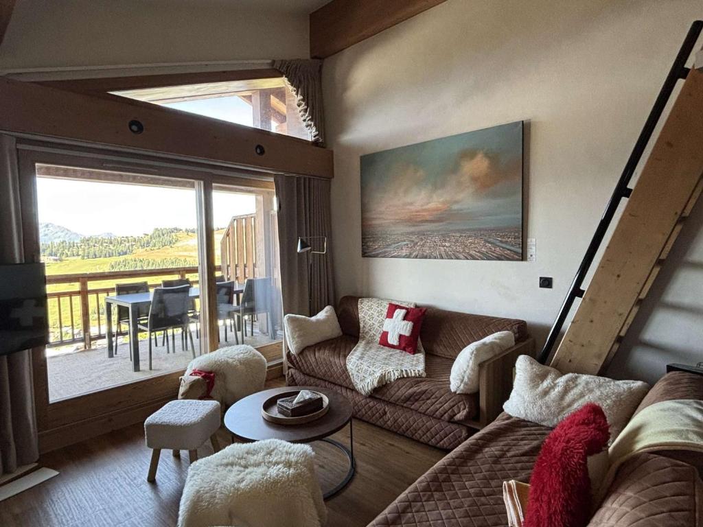 a living room with a couch and a table at Appartement spacieux avec spa, 4 chambres, parking, Les Saisies - FR-1-810-26 in Les Saisies