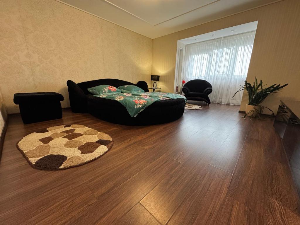 a living room with a black couch and a rug at One-Bedroom Apartment in the center in Dnipro