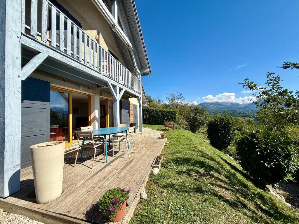 a deck with a table and chairs on a house at Un instant près du feu in Ponsonnas