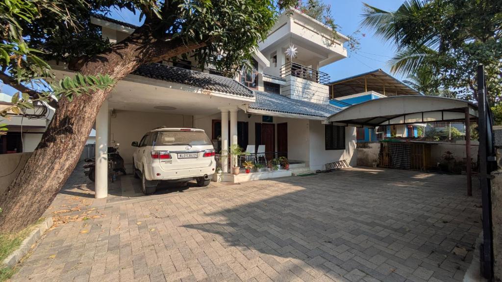 a white car parked in front of a house at Sinai Homestay in Trivandrum