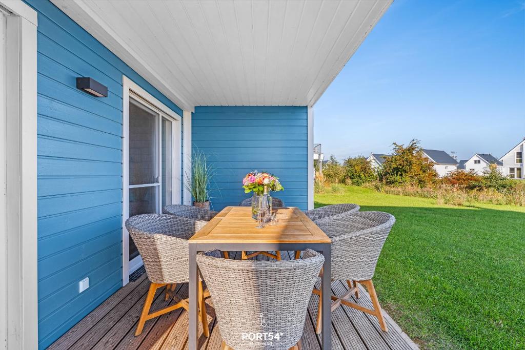 a patio with a table and chairs on a porch at Strandgeflüster in Olpenitz