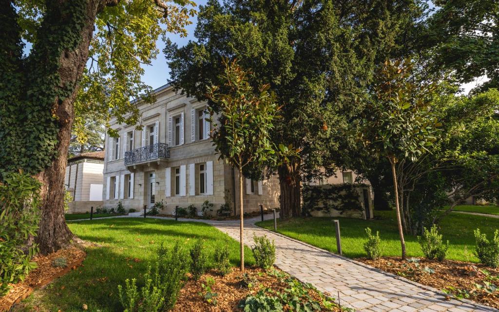 a large white house with trees in front of it at La Villa des Vignes in Saint-Émilion