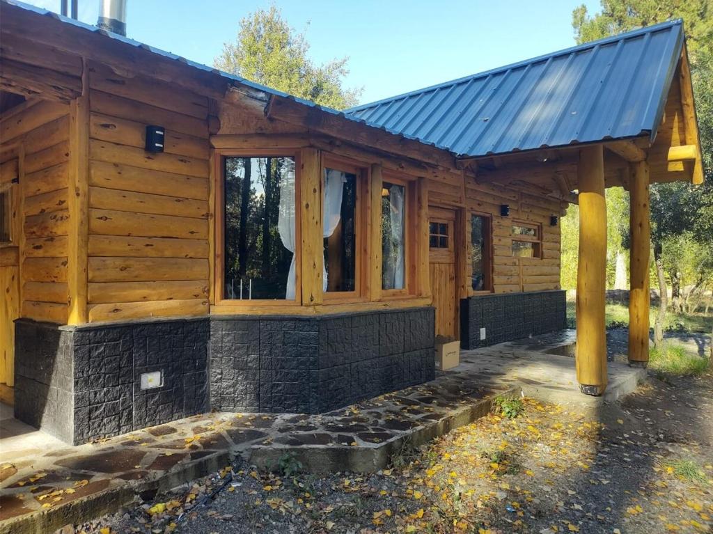 a log cabin with a solar roof at Lejana Casa de montaña in Lago Puelo
