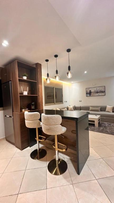 cocina con mesa, 2 sillas y sofá en Modern Flat in Khouribga, en Khouribga