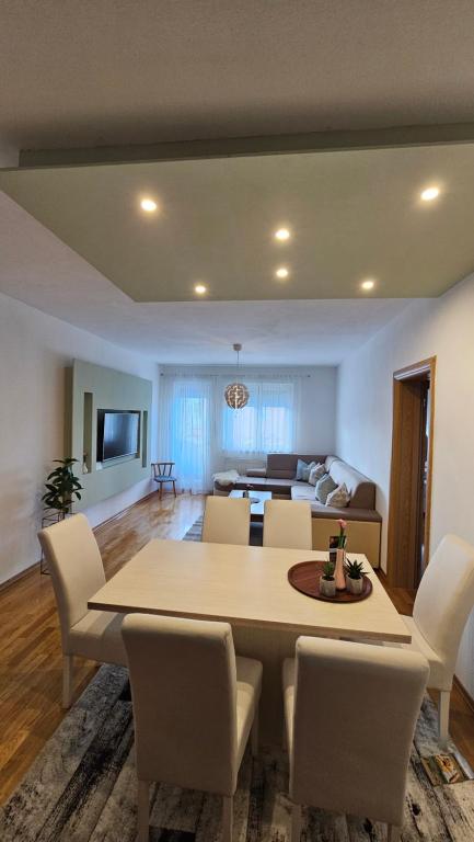 Un comedor y una sala de estar con mesa y sillas. en Apartman Pati, en Livno