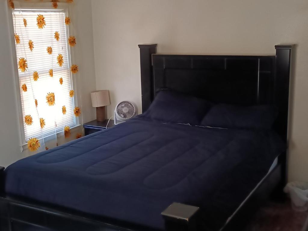 a bedroom with a bed with blue sheets and a window at Zen Gem Near Downtown Detroit and Grosse Pointe in Detroit