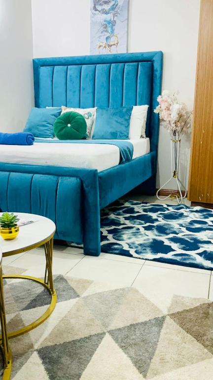 Una cama azul con una cabecera azul en una habitación. en Fitbull Homes Rm 210, en Nairobi