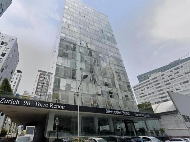 een hoog glazen gebouw met auto's voor het gebouw bij torre renoir 96, depto 306 in Mexico-Stad