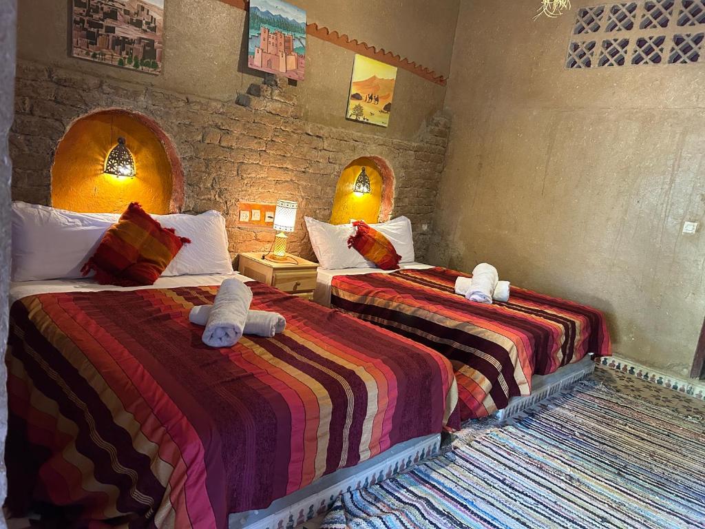 1 dormitorio con 2 camas con animales de peluche en Hôtel Camping La Liberté, en Merzouga