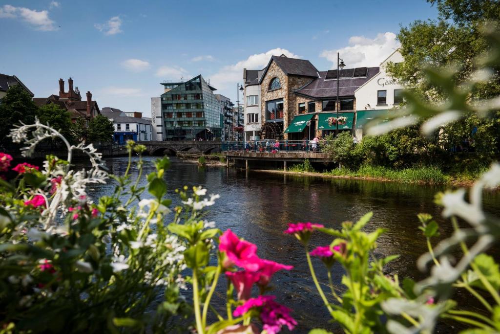 a bridge over a river with flowers in the foreground at The Courtyard View in Sligo