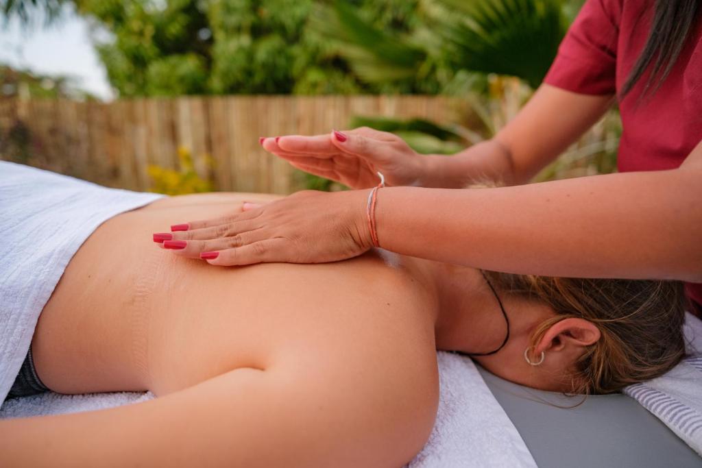 a woman getting a massage from a therapist at Kite Oasis Parajuru Casa Ilha in Parajuru