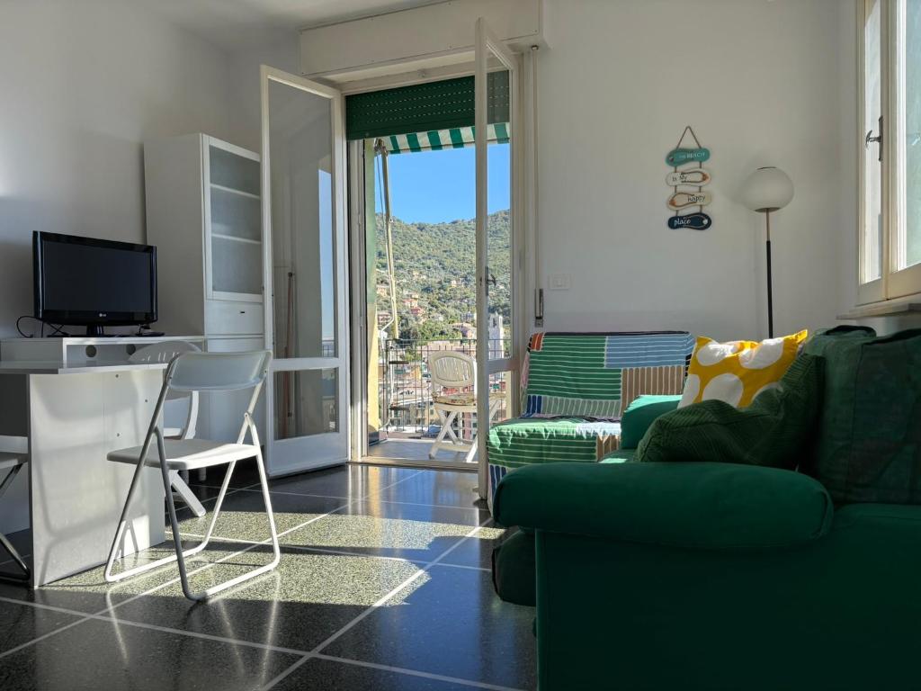 a living room with a green couch and a television at Il terrazzino sul Golfo in Recco