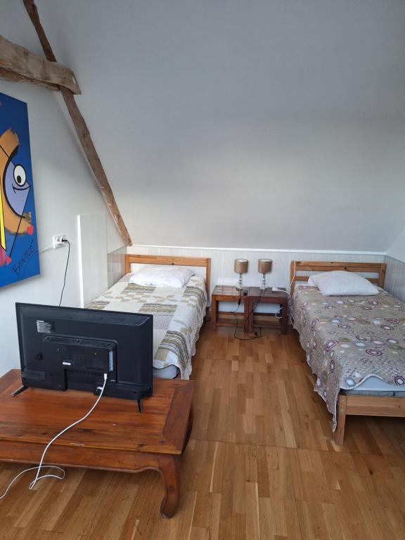 a room with two beds and a tv on a table at Benabeach in Sarzeau