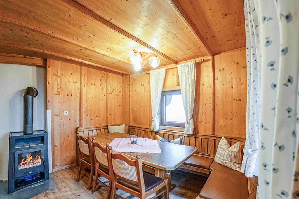 a dining room with a table and a wood stove at Otto&#039s Skihütte in Sölden