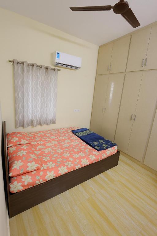 a bedroom with a bed and a ceiling fan at Bhakti Bliss Homestay - New Luxury 2bhk apartment in Tirupati with Kitchen and car parking in Tirupati