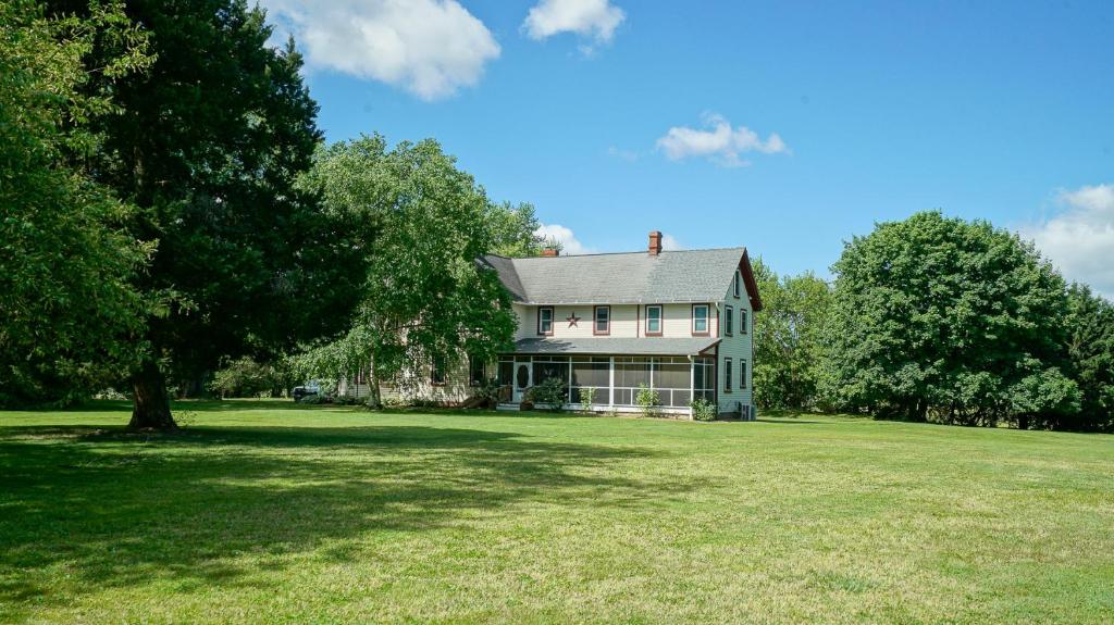 a large house on a grassy field with trees at The Still Pond Inn in Still Pond