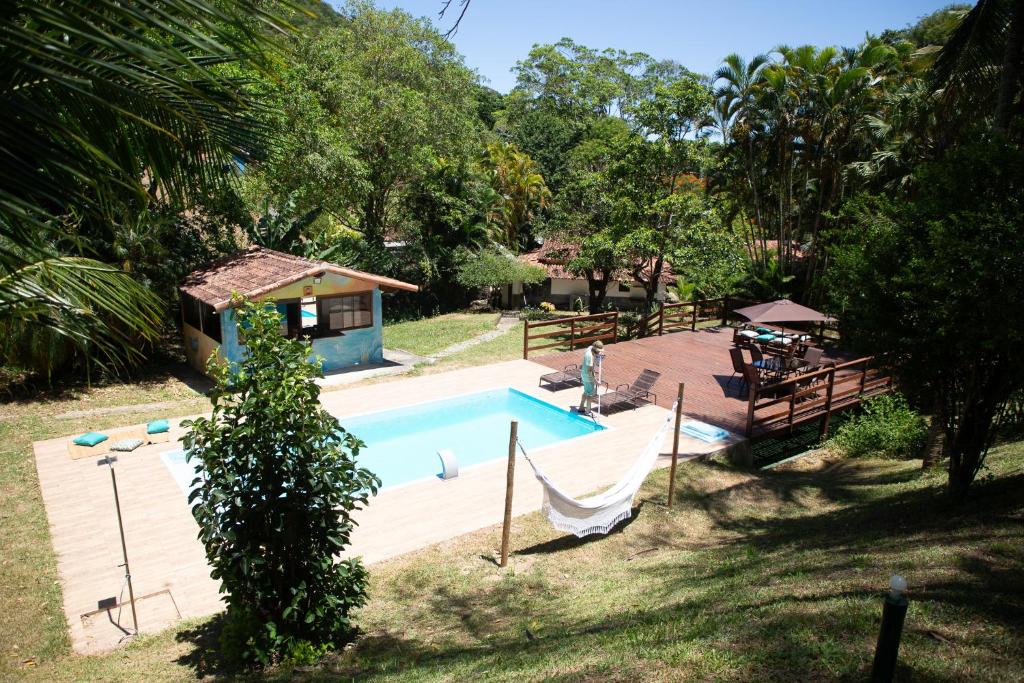 einen Pool mit Hängematte neben einem Haus in der Unterkunft Sitio Novo Dia in Saquarema