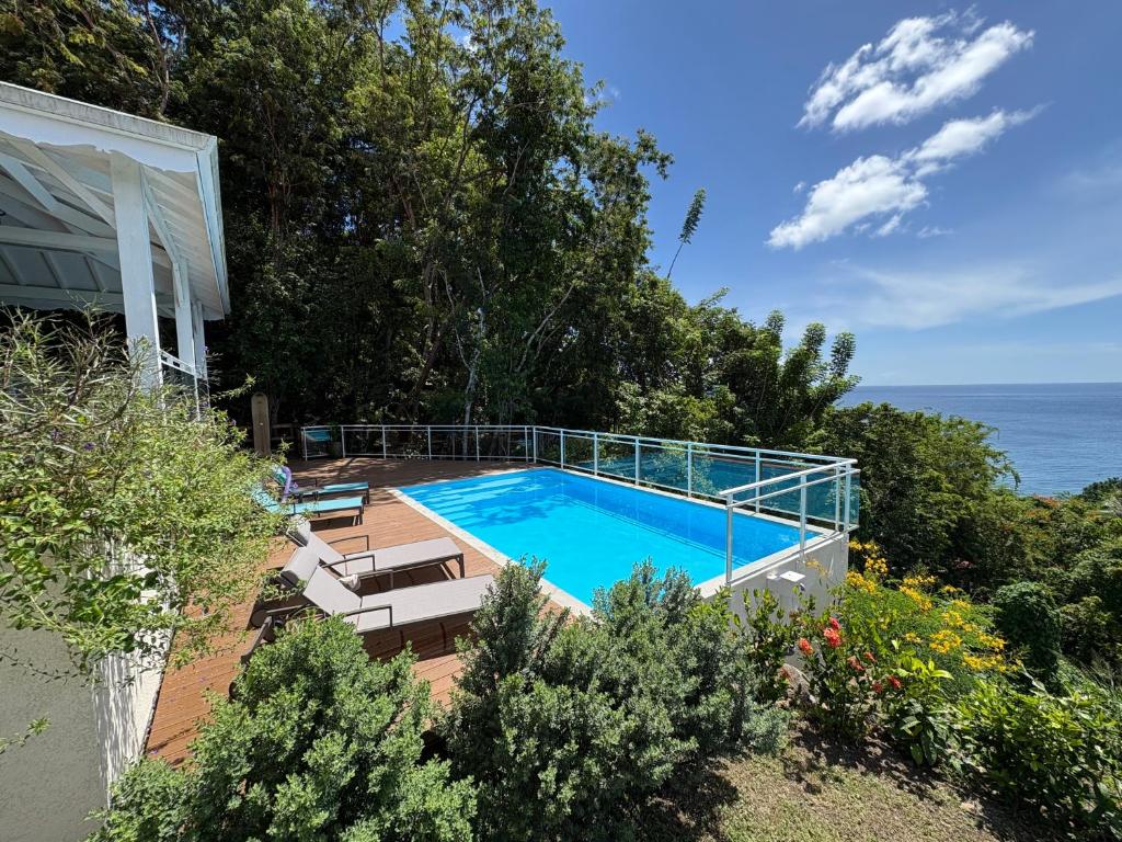 a swimming pool with a view of the ocean at Villa Ti'Kawet in Pointe-Noire