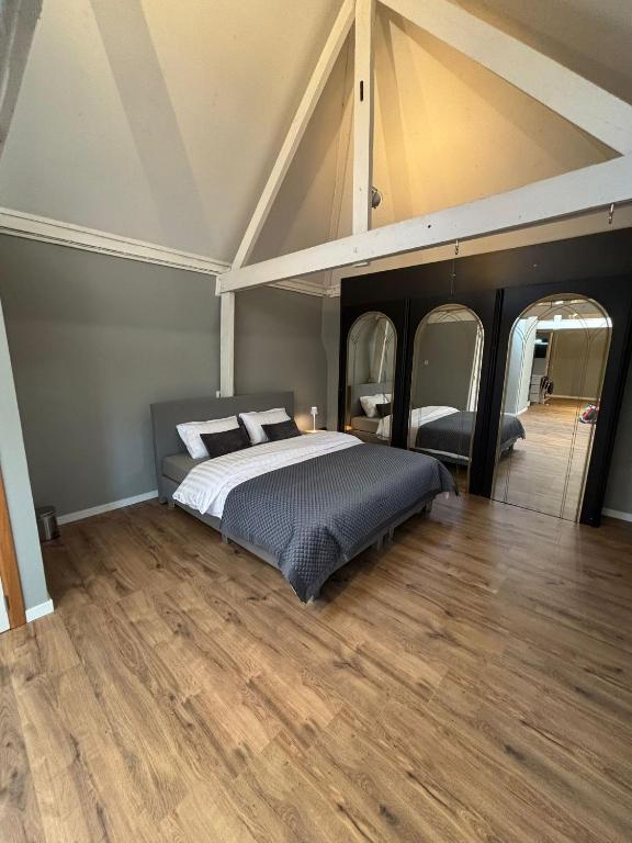 a bedroom with a large bed with two mirrors at Maison du Rempart Guesthouse a 15-Min Walk from Bruges Centre in Bruges