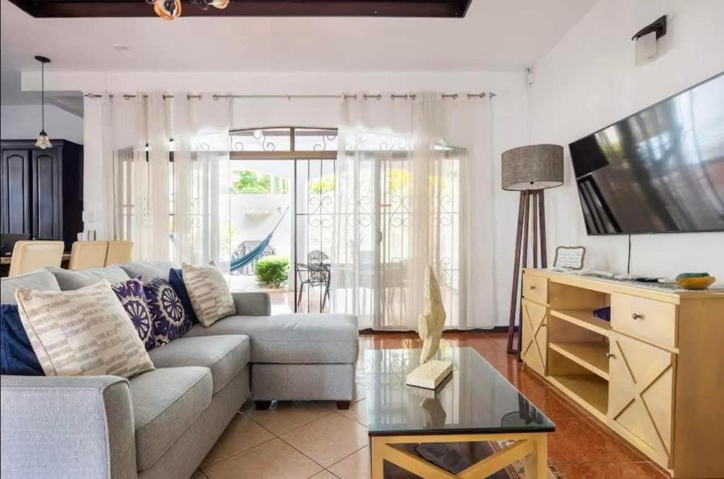 un salon avec un canapé et une télévision dans l'établissement Casa La Perla del Océano, à Herradura