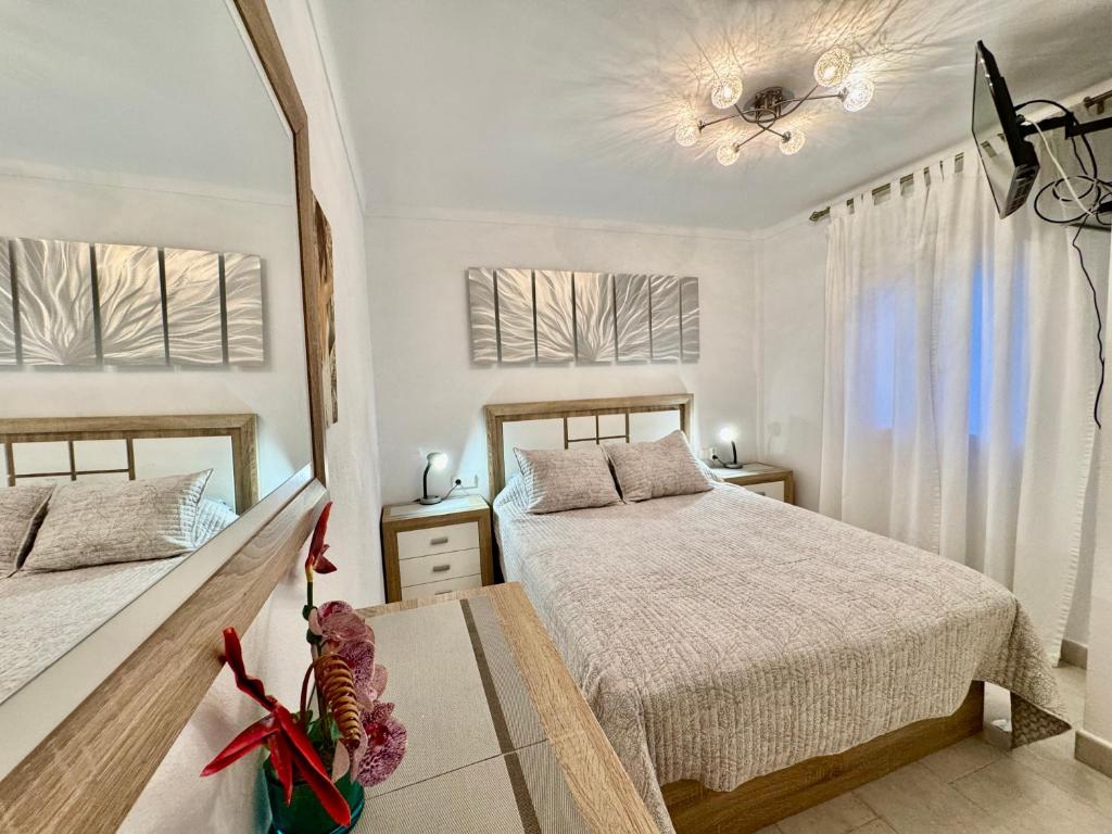 Un dormitorio con dos camas y dos ventanas. en BEACH FRONT APARTMENT in CALA MARSAL with the SEA VIEW !, en Portocolom