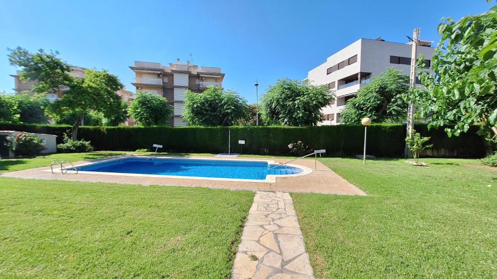 een zwembad in een tuin met een gebouw bij Cambrils Puerto in Cambrils