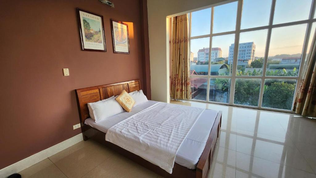 a bedroom with a bed and a large window at Hòa An Hotel- Early Morning Check-in in Cao Bằng