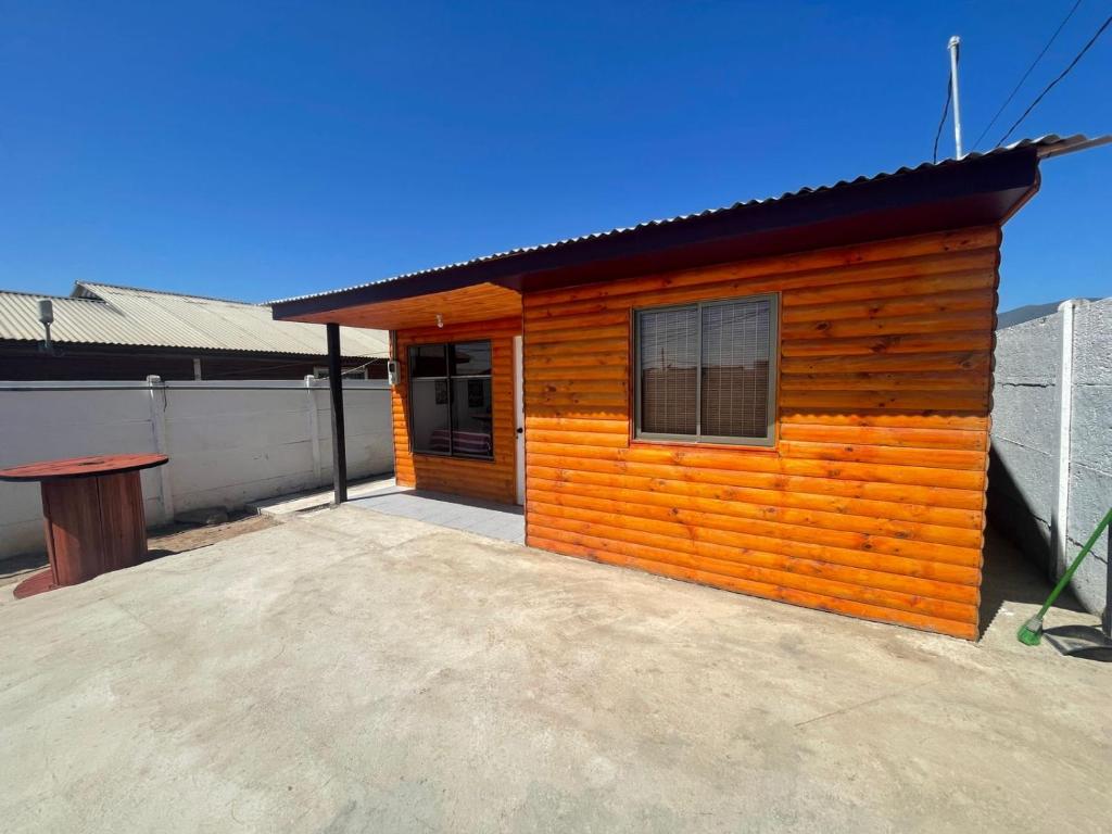 a small wooden house with a patio in front of it at Hispalis hostel in Coquimbo