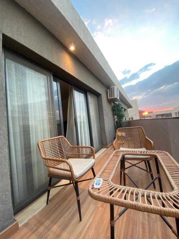 two chairs and a table on a balcony at The Vibe in Madinaty