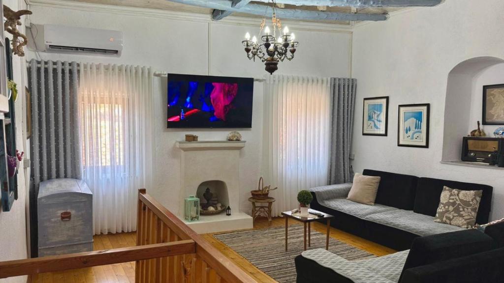 a living room with a couch and a fireplace at Old soul, Sea views in Dhërmi