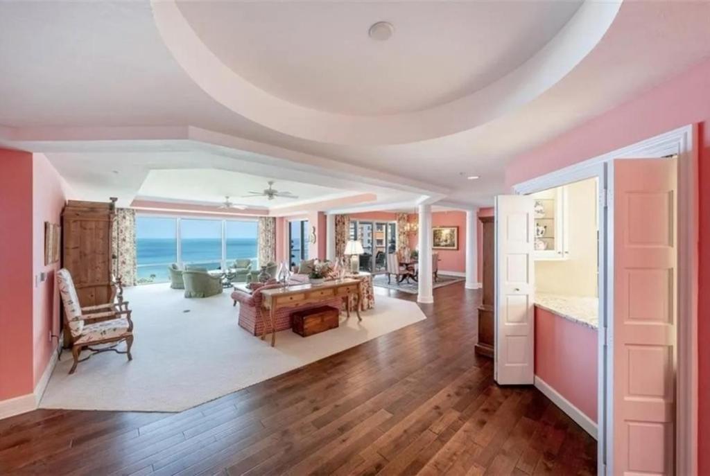 a living room with pink walls and a table at Spacious Gulf-view Residence in Naples