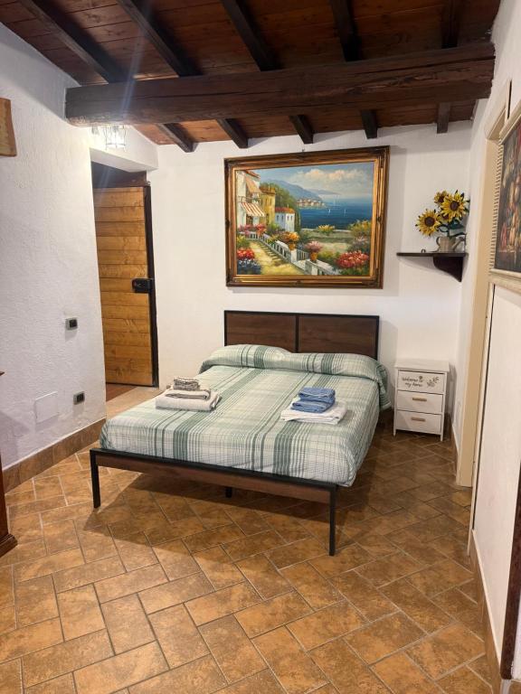 a bedroom with a bed with a painting on the wall at La Dimora in Formello