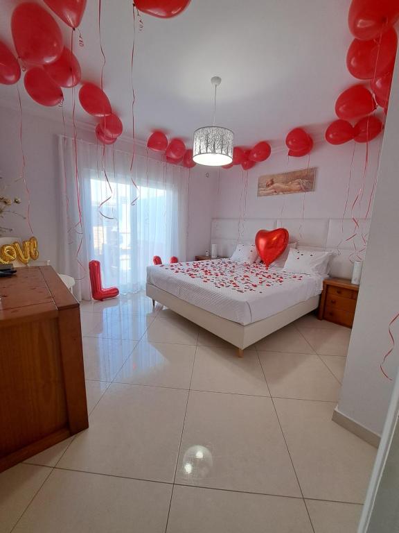 a bedroom with a bed with red hearts on the wall at Zurrinha holidays whit jacuzzi in Quarteira