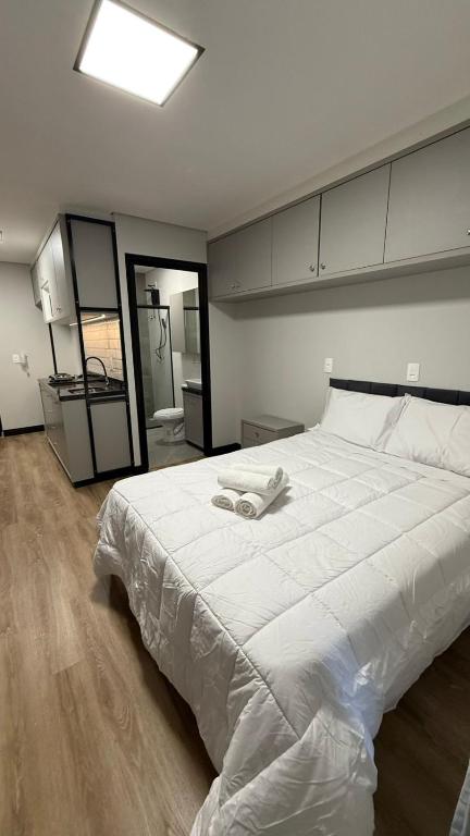 a large white bed with two towels on it at Residencial Roberto Luiz Chiodi in Campos Novos