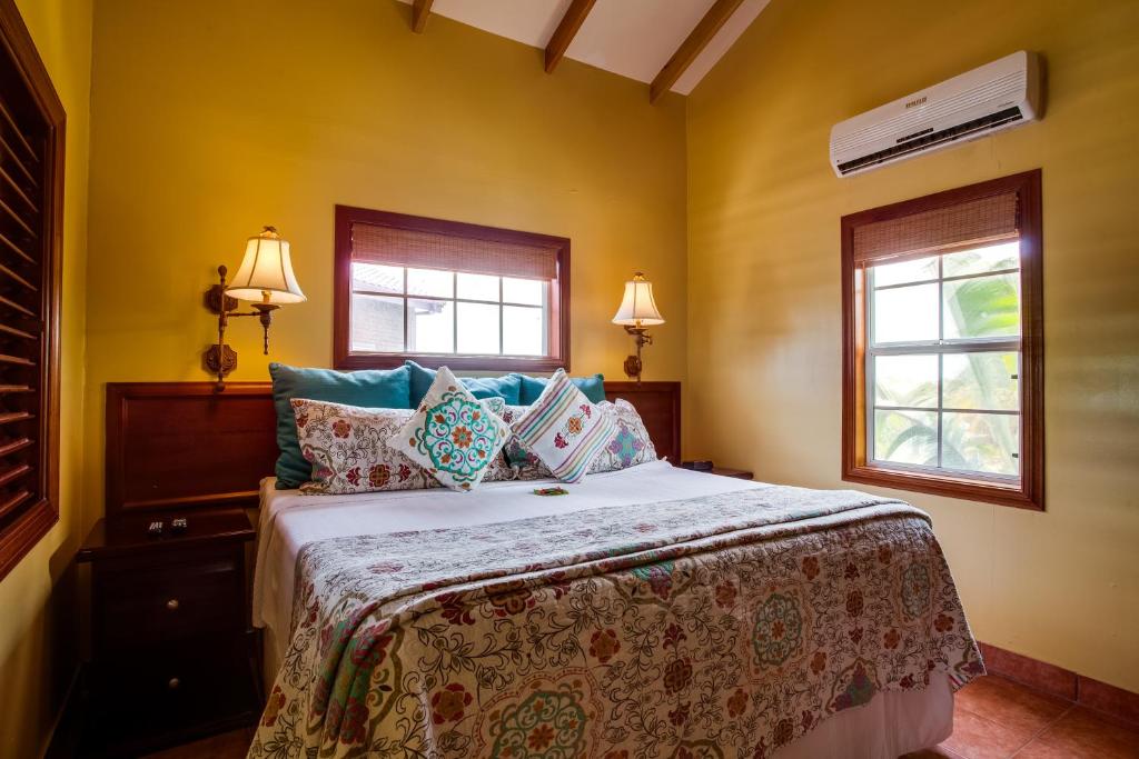 a bedroom with a bed and two windows at X'tan Ha- The Waterfront in San Pedro