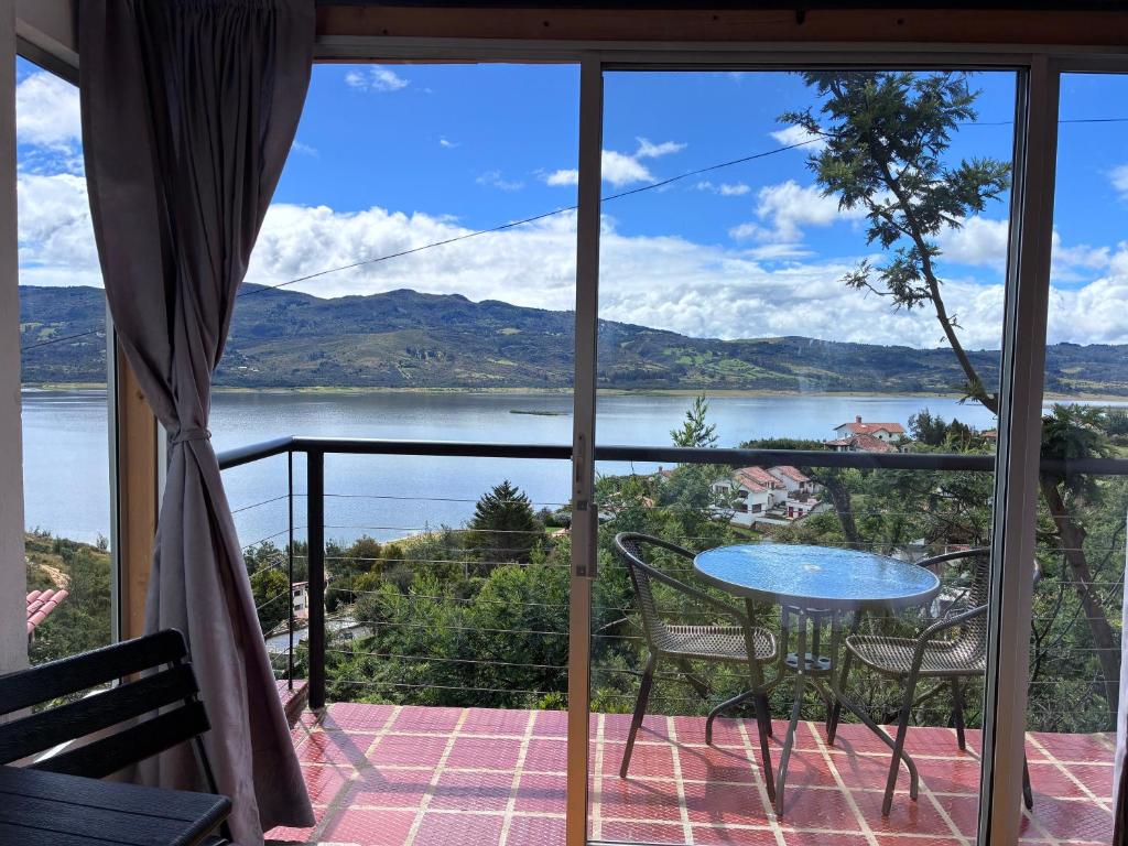 グアタビータにあるLakeview Apartment in the Heart of Guatavitaの湖の景色を望むバルコニー(テーブル、椅子付)