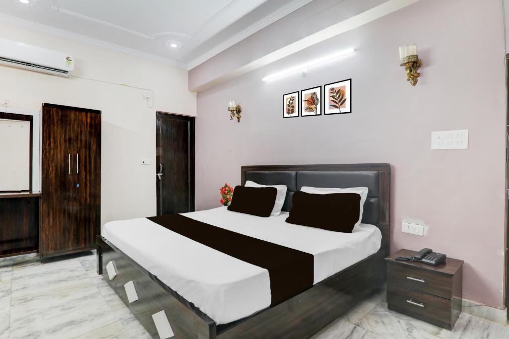 a bedroom with a large bed with white and black sheets at Hotel O RR Palace Hotel & Banquet in Bhauli