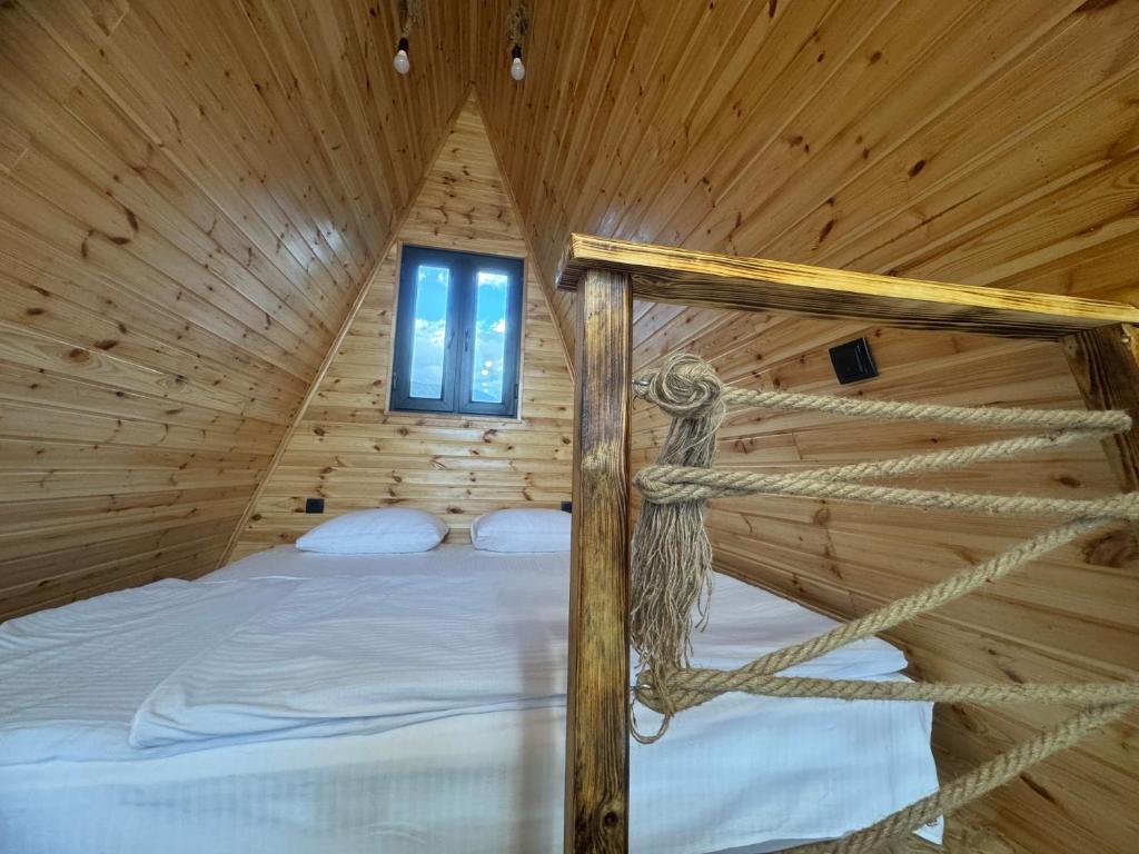 una camera da letto in una cabina di legno con letto di SapsanLodge a Artabuynkʼ