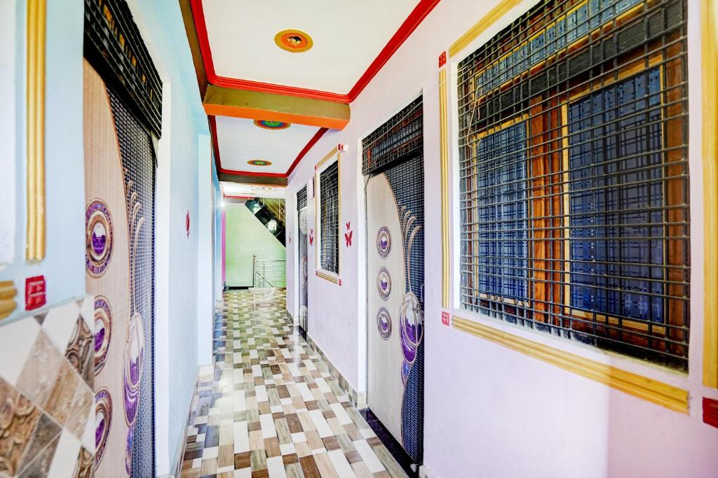 a corridor of a building with paintings on the walls at SPOT ON Pradhan Hotel in Bhīta