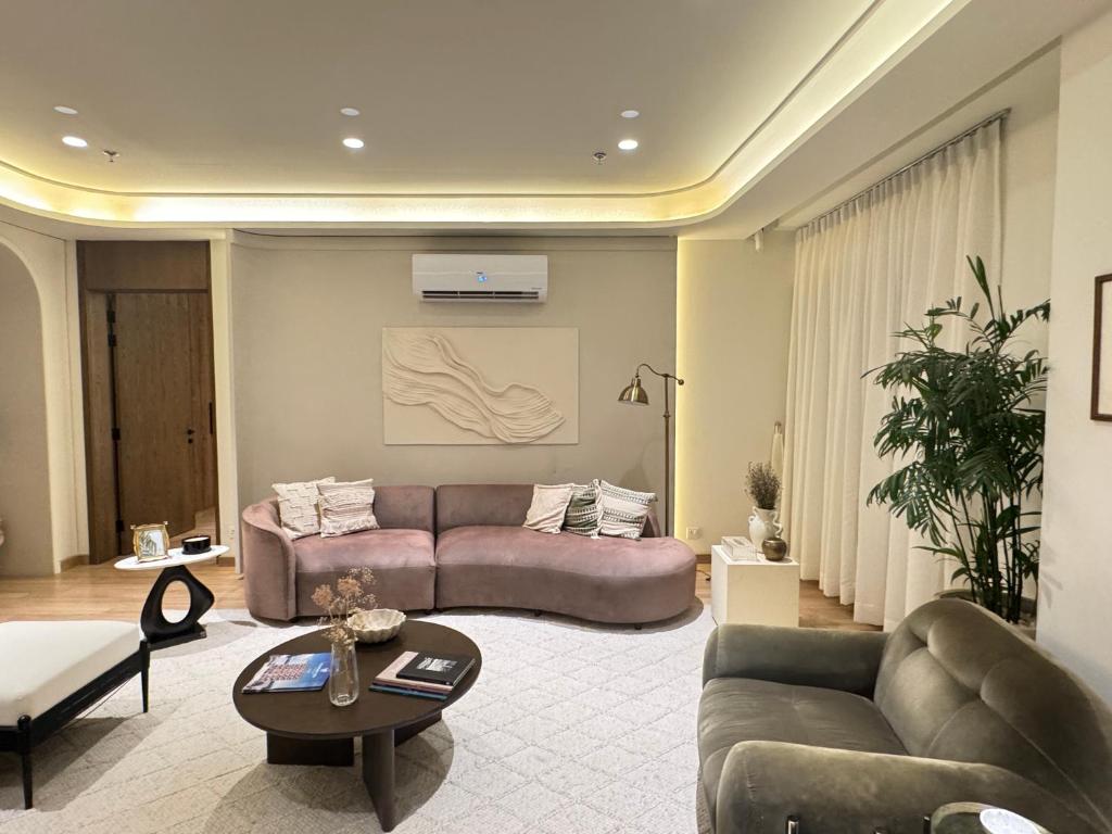una sala de estar con un sofá y una mesa en Penta Square Signature Apartments -City View DHA Phase 5 Lahore, en Lahore