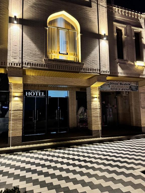 a hotel with a checkered sidewalk in front of a building at Old Saroy Hotel in Samarkand