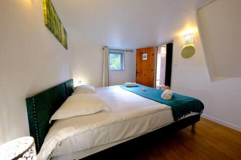 Gîte de l'Ecrin de l'Andelle - Un écrin de nature entre rivière et forêt في Morville-sur-Andelle: غرفة نوم بها سرير كبير في الغرفة