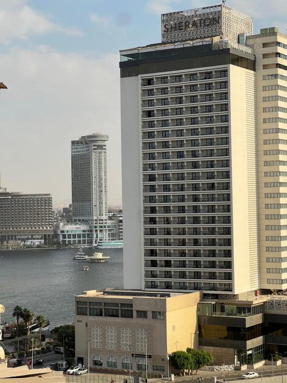 a large tall building next to a body of water at Downtown Luxury Suites - Partial Nile View in Cairo