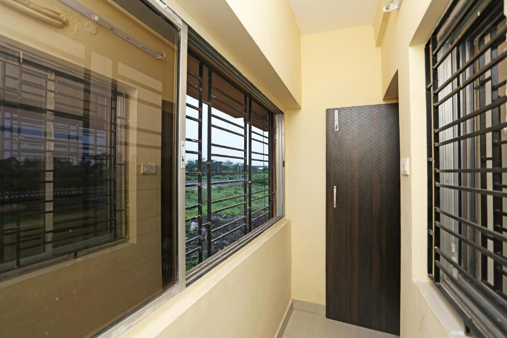 a hallway with a window with a view of a train at Hotel O Eco Inn in Jojera