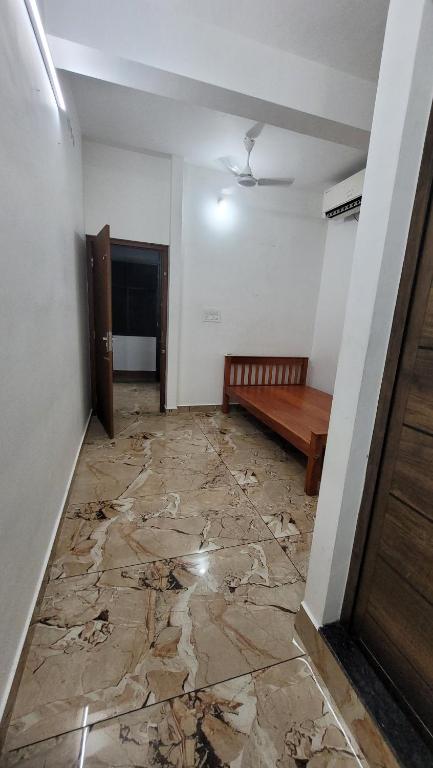 ein Raum mit einer Bank und ein Raum mit einer Wand in der Unterkunft YandY in Ernakulam